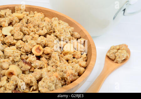Milk with muesli in a bamboo bowl on wooden table Stock Photo