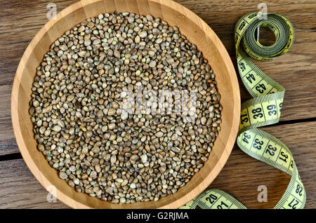 Hemp seeds in a bamboo bowl with centimeter on wooden table Stock Photo