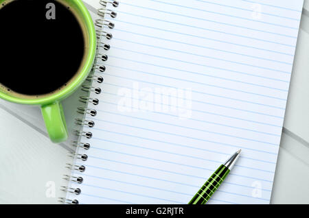 Empty notebook with pen and cup of coffee on wooden table Stock Photo