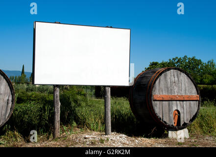 blank billboard in the countryside cultivated with traditional wooden barrel Stock Photo