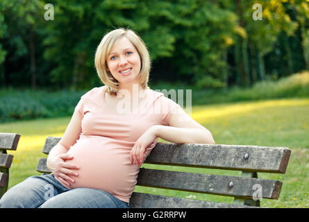 Pregnant woman in the park Stock Photo