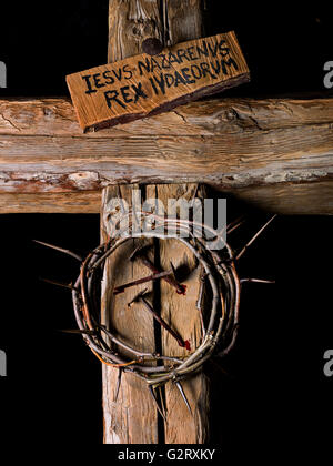 Crown of thorns and nails of Christ with blood on wooden cross Stock Photo