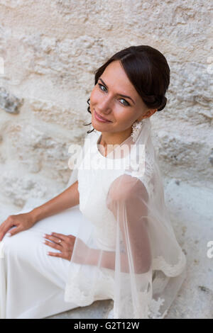Beautiful bride outdoors posing on the steps Stock Photo