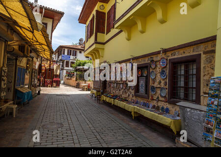 ANTALYA, TURKEY - APRIL 23, 2016 : View of Kaleici old town streets with small souvenir shops, on cloudy blue sky background. Stock Photo