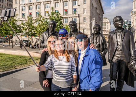 American tourists take a selfie by the Beatles statue at Liverpool pierhead. Stock Photo