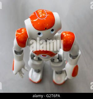 A small robot with human face and body - humanoid. Artificial Intelligence - AI. Orange robot. Stock Photo