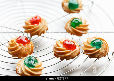 sicilian almond pastries with candied cherries on cake rack Stock Photo