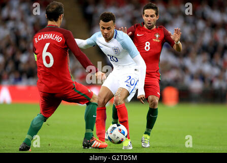 England's Dele Alli (centre) in action with Portugal's Joao Moutinho (right) and Ricardo Carvalho during the International Friendly at Wembley Stadium, London. Stock Photo
