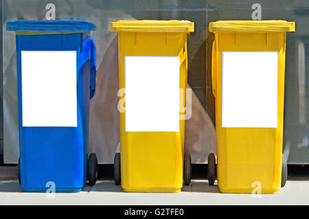 Three colorful trash cans on street Stock Photo