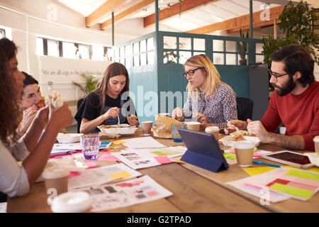 Team Of Designers Having Working Lunch Meeting In Office Stock Photo