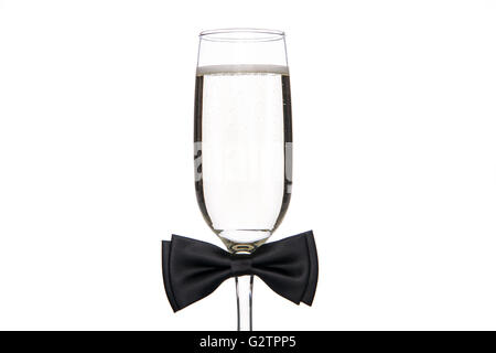 Glass of champagne with black bow tie on white background Stock Photo