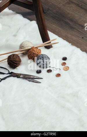 button, scissors and yarn ball on wooden chair, handmade Stock Photo ...