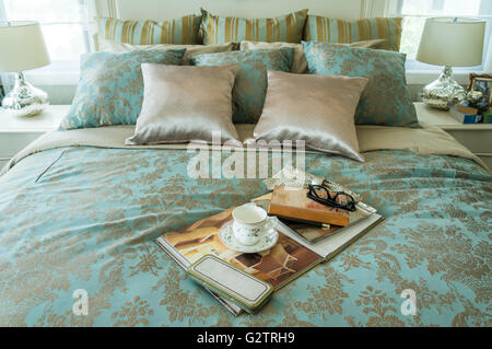 Decorative set with book,tea set and glasses on the bed Stock Photo