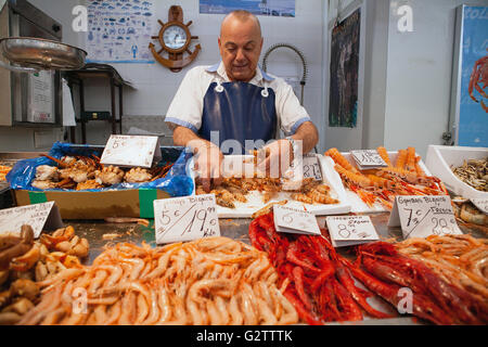 Spain, Andalucia, Cadiz, A fishmonger prepares an order for langoustines at his stall in the Central Market. Stock Photo