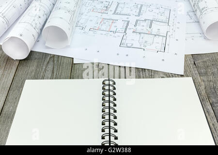 notepad with rolls of architectural blueprints and technical drawings Stock Photo
