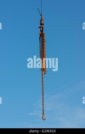 Industrial chains and hooks isolated against blue sky. Stock Photo