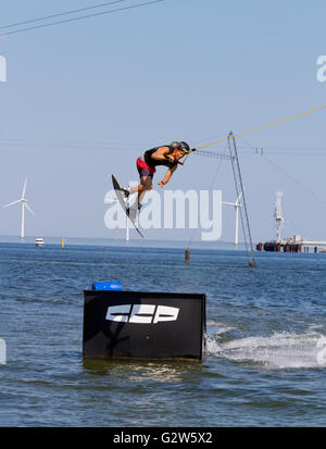 Wakeboarder at Copenhagen Cable Park. Middelgrunden Offshore Wind Farm in the background. Stock Photo