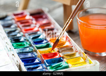 Set of watercolor paints and paintbrushes for painting closeup. Selective focus. Stock Photo