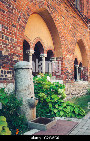 Public Water Fountain with flowing water inside the inner courtyard of Riga Cathedral. Riga, Latvia. Stock Photo