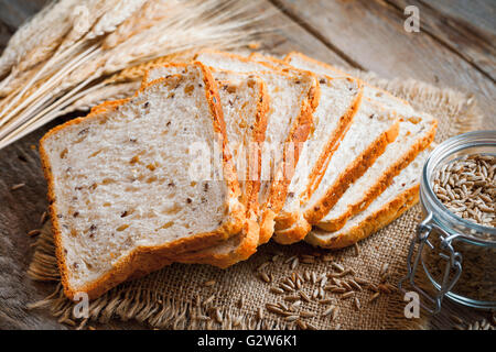 Wheat toast bread, spikes and wheat grains on kitchen table. Stock Photo