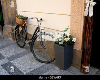 Old bicycle with wicker basket on the street Stock Photo