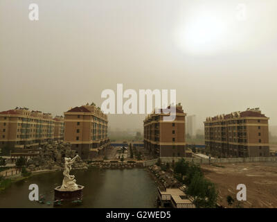 Zhangye, China's Gansu Province. 3rd June, 2016. Buildings are shrouded in sand and dust in Zhangye City, northwest China's Gansu Province, June 3, 2016. A sandstorm hit the city on Friday afternoon. Credit:  Cheng Lin/Xinhua/Alamy Live News Stock Photo