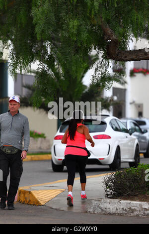 Girl wearing headphones jogging along Coste Verde, Miraflores, Lima, Peru Stock Photo