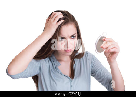 Woman looking at the first grey hair on her scalp Stock Photo