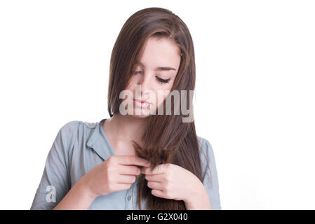 Young woman looking at split ends. Damaged long hair Stock Photo