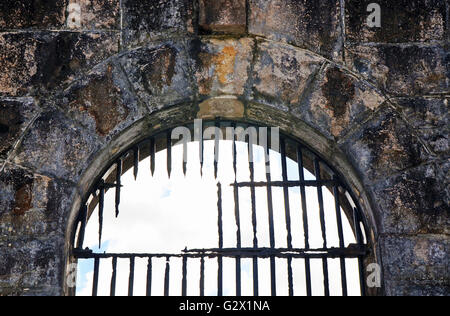 Broken rusty iron bars on old jail (gaol) arched window- evidence of an escape or jailbreak Stock Photo