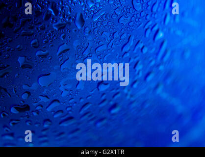 Water drops on radial blue background, soft focus, close up Stock Photo