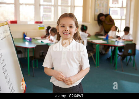 Portrait Of Elementary School Pupil With Whiteboard In Class Stock Photo