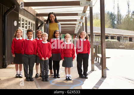 Portrait Of Elementary Pupils And Teacher In Playground Stock Photo