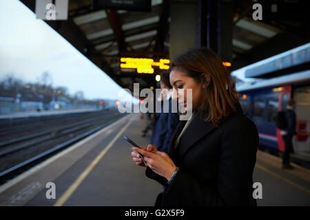 Businesswoman On Platform Waiting For Train Home Stock Photo