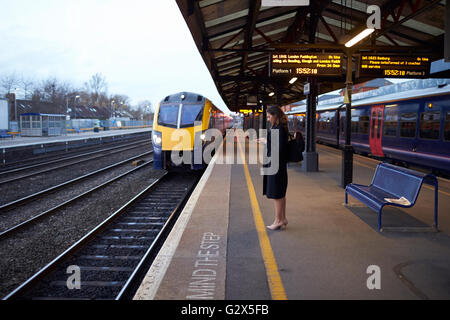 Businesswoman On Platform Waiting For Train Home Stock Photo