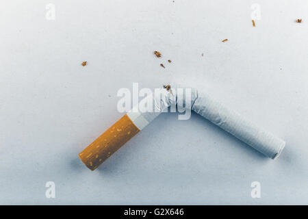 Quit Smoking - Low contrast image of a broken unsmoked cigarette over white background Stock Photo