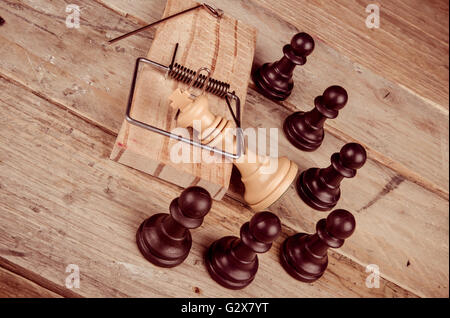 King  in a mousetrap surrounded by pawns, a concept Stock Photo