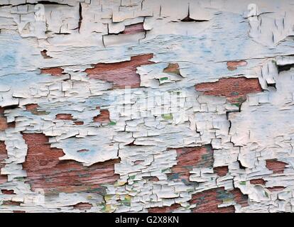 The paint is falling off from the wall of an old wooden house Stock Photo