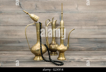 Vintage arabic jug, vase, teapot. Golden oriental decorations and islamic rosary beads Stock Photo