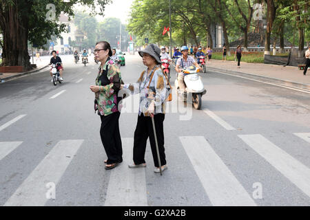 elderly ladies cross road Hanoi crossing Stock Photo