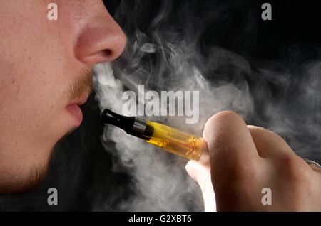 Man smoking an electronic cigarette and exhaling vapour Stock Photo