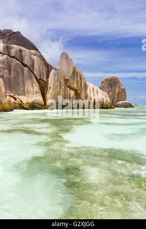 Turquoise water and coral reefs in front of the La Digue coastline, Seychelles with granite rocks Stock Photo