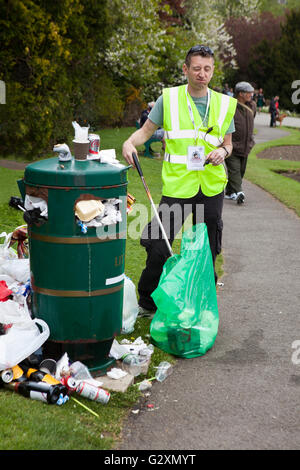 Street cleaner collecting garbage, garbage, waste trash, dirty paper, urban, refuse, junk, pollution, from overflowed bins, Southport, Merseyside, UK Stock Photo