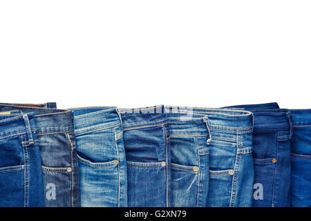 Row of fashion different jeans isolated on white background. Stock Photo