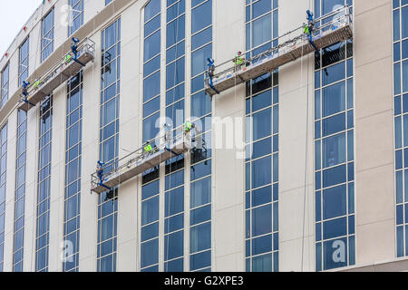 Window washers on electric scaffolding cleaning windows on high rise building in Nashville, Tennessee Stock Photo