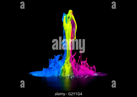 Colorful paint splashing on an audio speaker isolated on black. Stock Photo