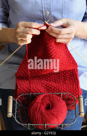 woman hands knitting red woolen scarf Stock Photo