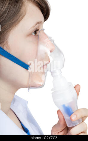 medical inhalation treatment - girl inhales with face mask of modern inhaler isolated on white background Stock Photo