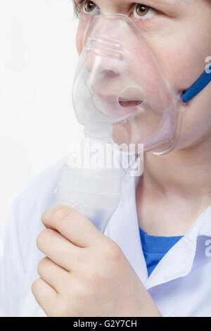 medical inhalation treatment - girl breathes with face mask of modern jet nebulizer Stock Photo
