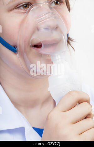 medical inhalation treatment - girl inhales with face mask of modern jet nebulizer Stock Photo